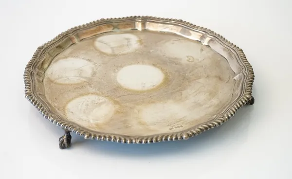 A silver salver, of shaped circular form, having a Chippendale style rim, raised on three ball and claw feet, diameter 26cm, Sheffield 1911, weight 63