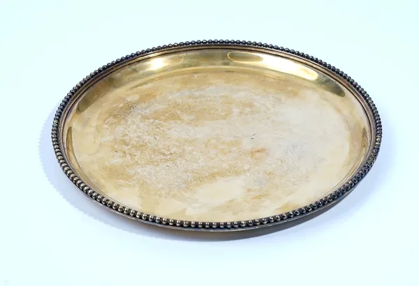 A French silver gilt circular salver, decorated with a beaded rim, detailed Cardeilhac Paris, diameter 27cm, weight 658 gms.