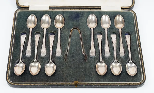 A set of twelve silver coffee spoons and a matching pair of silver sugar tongs, the Old English pattern handles with engraved decoration, Sheffield 19