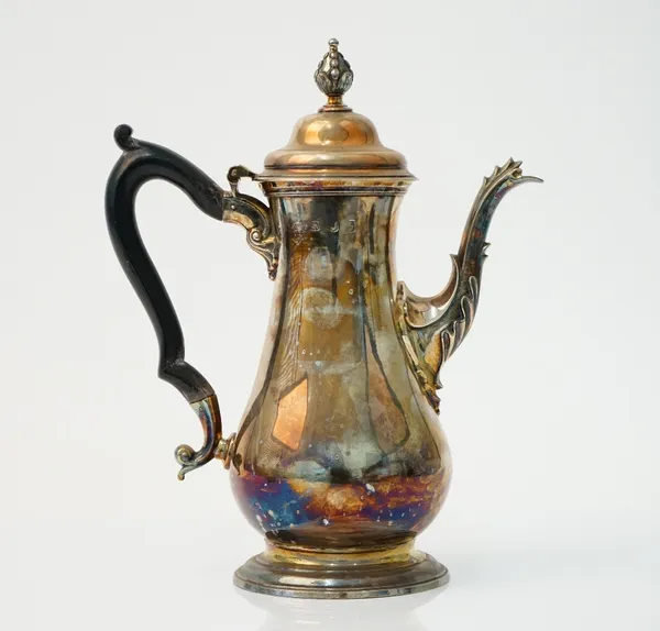 A George III silver coffee pot of baluster form having a bud finial and raised on a circular foot, with a replacement wooden handle, makers mark indis