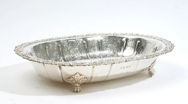 A silver large oval bowl, with floral and scroll decoration to the centre and with a floral and scroll moulded border, raised on four paw feet, length