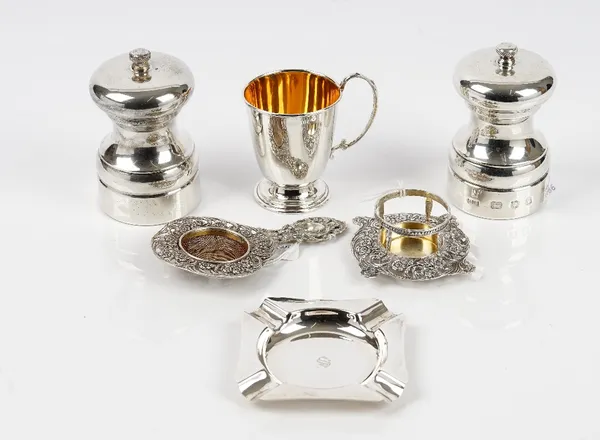 A pair of silver mounted Peter Piper peppermills, each of capstan form, London 1988, a christening mug, a square ashtray, Birmingham 1978 and a foreig