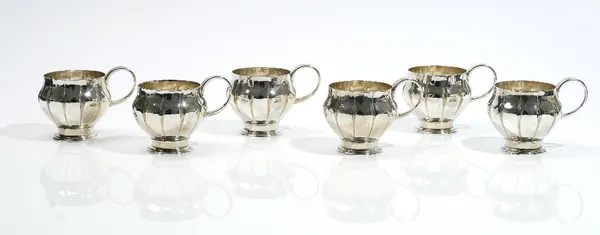 A set of six silver cups, each with tapered fluting decoration, raised on a circular foot, height 6.5cm, retailed by Asprey London, London 1964, combi