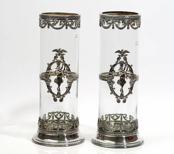 A pair of European silver plated metal mounted cylindrical glass vases, with pierced decoration in the French Empire style, on circular bases, height