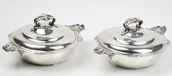 A pair of French twin handled vegetable dishes and covers, each with cast and scroll decorated handles and with a cast and pierced handle to the detac