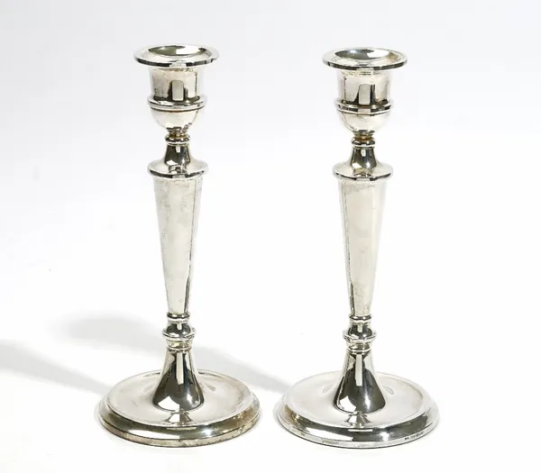 A pair of silver table candlesticks, each with a tapered stem, raised on a circular foot, Birmingham 1989, (loaded), height 25cm.