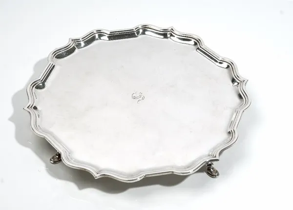 A silver salver, of shaped circular form, in the Chippendale style, raised on four pad feet, retailed by Harrods London, diameter 31cm, weight 828 gms