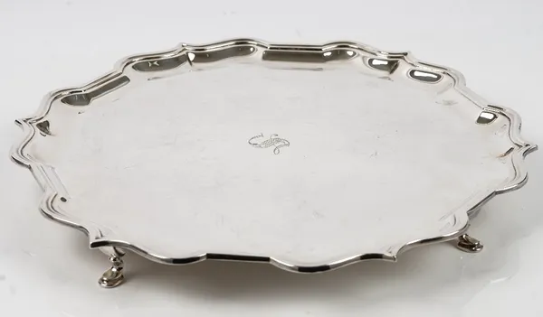 A silver salver of shaped circular form, having a piecrust rim in the Chippendale style raised on four pad feet, diameter 37cm, Sheffield 1977, weight