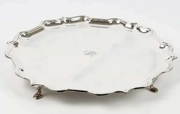 A silver salver of shaped circular form, having a piecrust rim in the Chippendale style raised on four pad feet, diameter 36.5cm, Sheffield 1968, weig