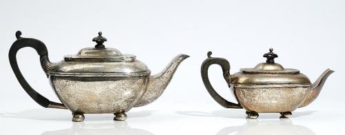 A graduated pair of Regency style silver teapots, one William Hutton & Sons, date letter rubbed, one H Matthews, Birmingham 1908, rounded oblong, with