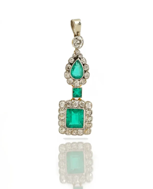 An emerald and diamond set pendant, the  oval cut diamond suspension loop milligrain set suspending a pear cut emerald in a cluster of old mine cut di