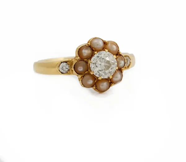 A late Victorian gold, diamond and seed pearl ring, of cluster design, the central circular cut diamond approximately 0.45ct, claw set in a surround o