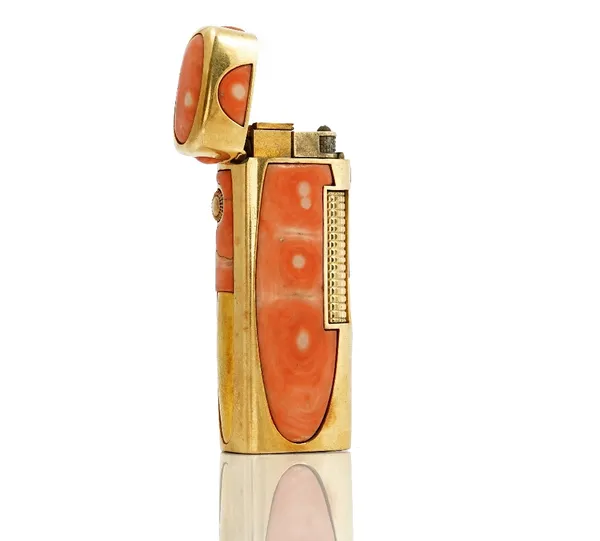 A gold mounted coral curved rectangular cased gas lighter, detailed 750, the hinged cover and the sides mounted with coral panels.