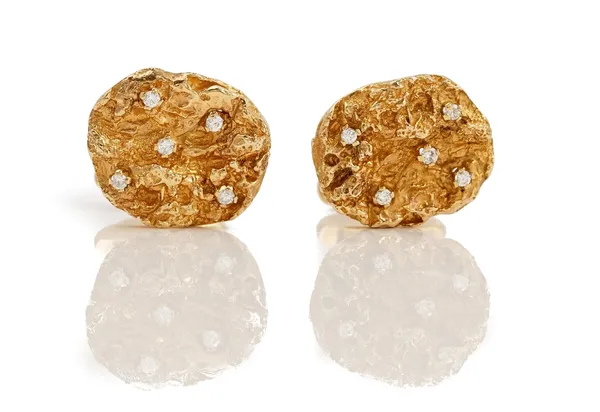 A pair of 9ct gold and diamond dress cufflinks, each oval front with cast decoration and claw set with five circular cut diamonds, in an abstract desi