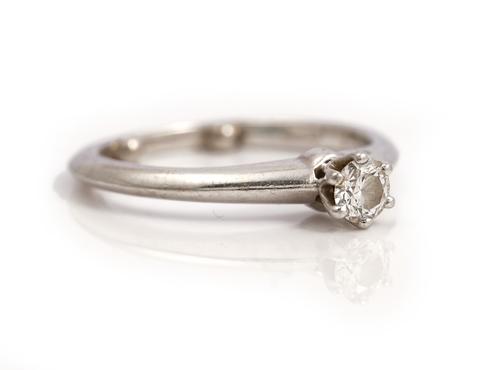 A Tiffany & Co. platinum and diamond single stone ring, claw set with a circular cut diamond, ring size F 1/2 (note sizing beads), with a Tiffany & Co