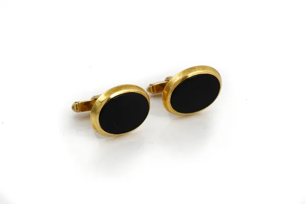 A pair of 9ct gold mounted black onyx cufflinks, each mounted with an oval black onyx to the front and with a folding bar fitting at the back, London