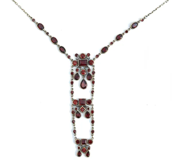 A gold and garnet pendant necklace, the front with three graduated sections, mounted with circular, square, rectangular and pear shaped garnets, on a