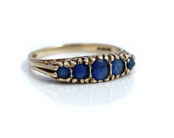 A 9ct gold and sapphire five stone ring, mounted with a row of graduated sapphires, the mount decorated with scroll pierced sides, ring size O and a h