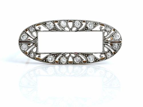 A gold and diamond brooch, in an oval openwork design, with a rectangular centre, the pierced border mounted with cushion shaped diamonds, gross weigh