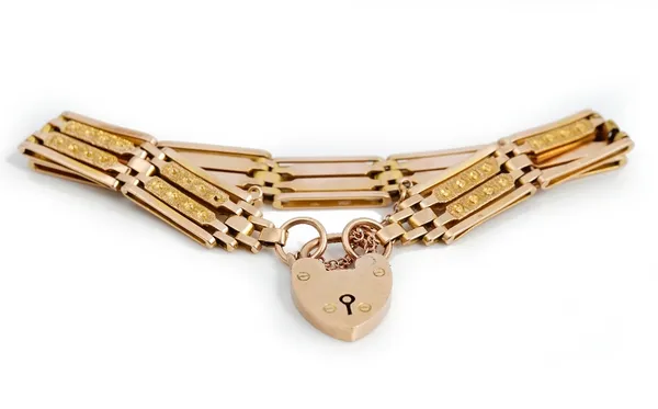 A gold decorated and plain bar and oval link gate bracelet, detailed 9ct, on a gold heart shaped padlock clasp detailed 9ct, weight 18.7gms.