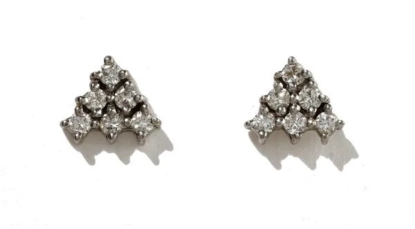 A pair of diamond earstuds, each claw set with six circular cut diamonds in a triangular design, the backs with unmarked posts and butterfly clips, de