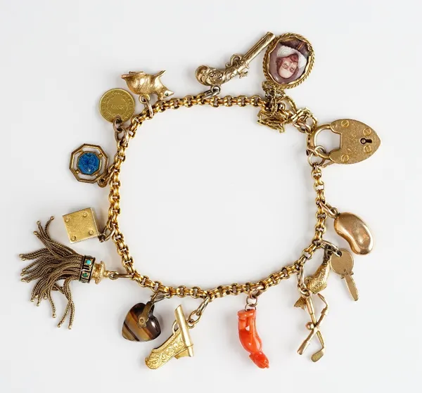 A gold charm bracelet, on an 18ct gold heart shaped padlock clasp, fitted with fourteen gold and other charms, including an enamelled oval portrait of