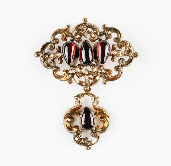 A Victorian gold and carbuncle garnet brooch, in a scroll pierced openwork design, mounted with three pear shaped carbuncle garnets, the front with a