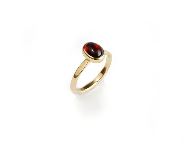 A gold ring, collet set with an oval carbuncle garnet, the shank with faceted decoration, unmarked, ring size M, gross weight 3.7 gms.