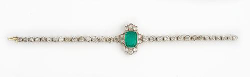 An emerald and diamond bracelet mounted with the cushion cut emerald to the centre, between two rows of three cushion shaped diamonds and with a pair