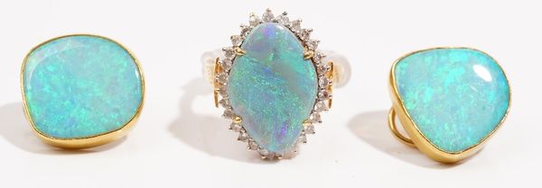 A precious yellow metal opal and diamond-set dress ring, the precious opal claw-set to a surround of circular cut diamonds; and a pair of opal doublet