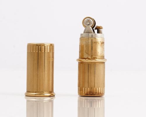 A Cartier London 9ct gold cased petrol lighter, of cylindrical form, with banded decoration, detailed Xmas 1947, length 5.3cm, gross weight including