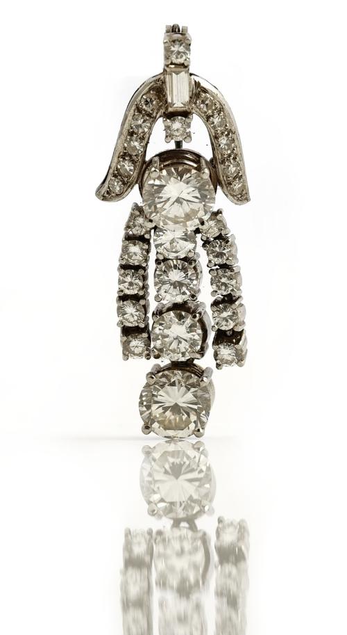 A diamond brooch, the front mounted with a row of four graduated circular cut diamonds and with the principle circular cut diamond mounted above, othe