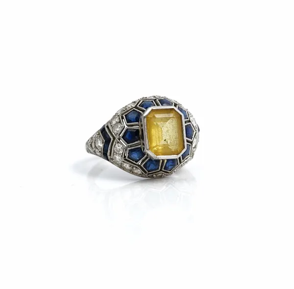 A yellow beryl, sapphire and diamond ring, circa 1930s, mounted with the cut cornered rectangular emerald cut yellow beryl at the centre, in a surroun