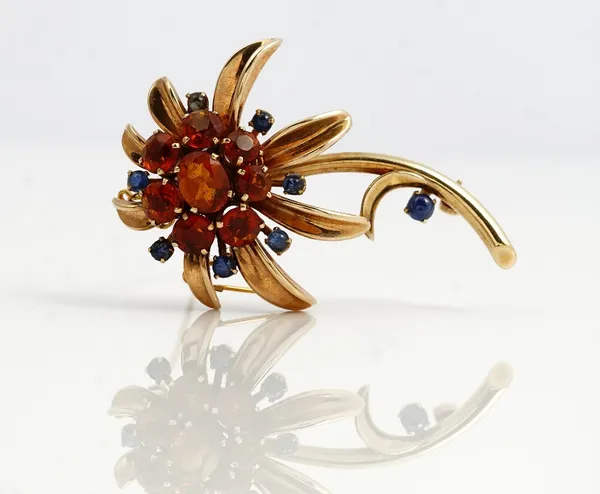 A 9ct gold, citrine and sapphire brooch, designed as a flower spray, mounted with the principal oval cut citrine to the centre, in a surround of seven