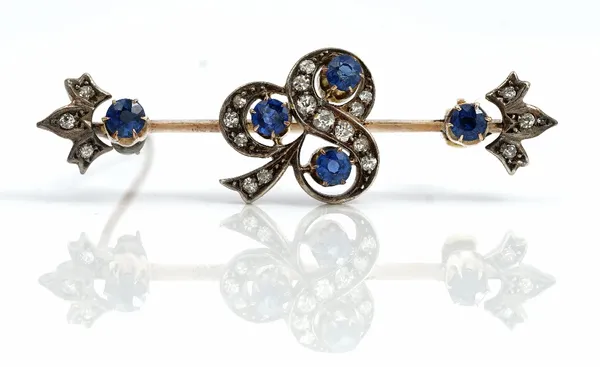 A gold and silver set, diamond and sapphire brooch, the centre with a trefoil shaped motif, mounted with three cushion shaped sapphires and otherwise