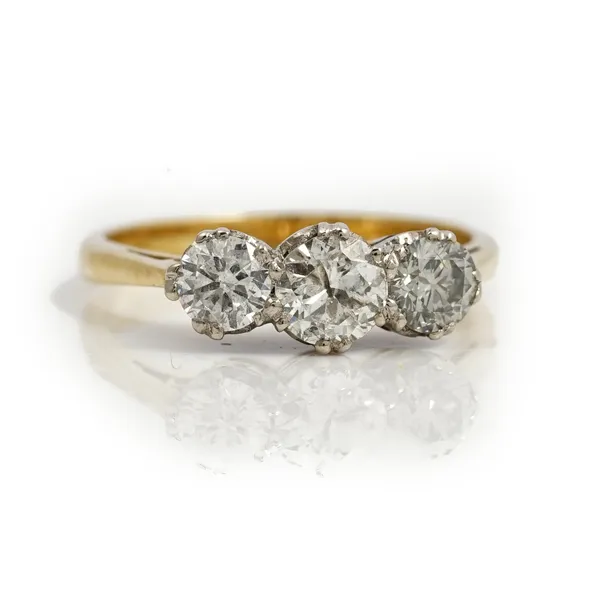 A gold and diamond set three stone ring, claw set with a row of circular cut diamonds and with the principal diamond mounted at the centre, detailed 1