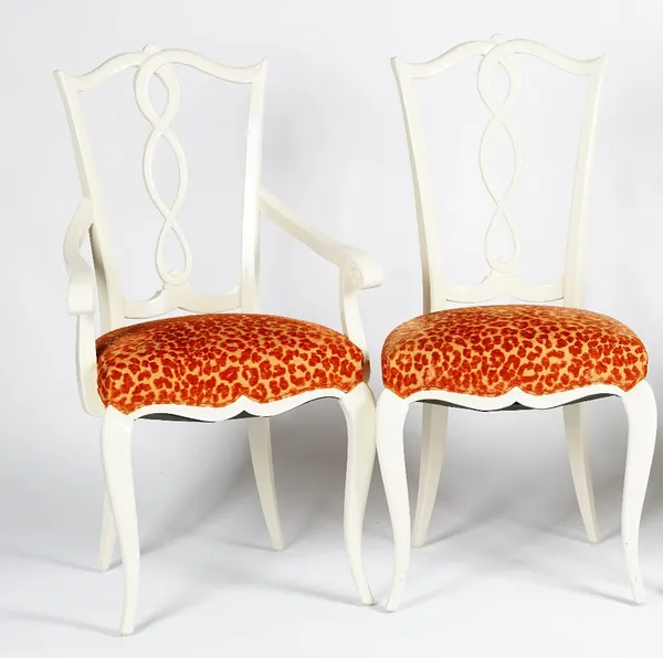 A set of twelve glossy white finish dining chairs, with pierced splats, orange ocelot upholstered stuff-over seats, on cabriole legs, including one el