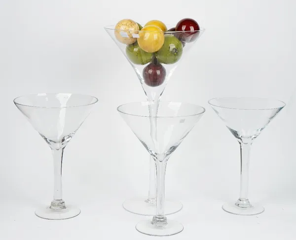 A tall contemporary glass goblet containing a collection of faux marble balls and three smaller similar glass goblets (qty).The tallest is 64cm, the s