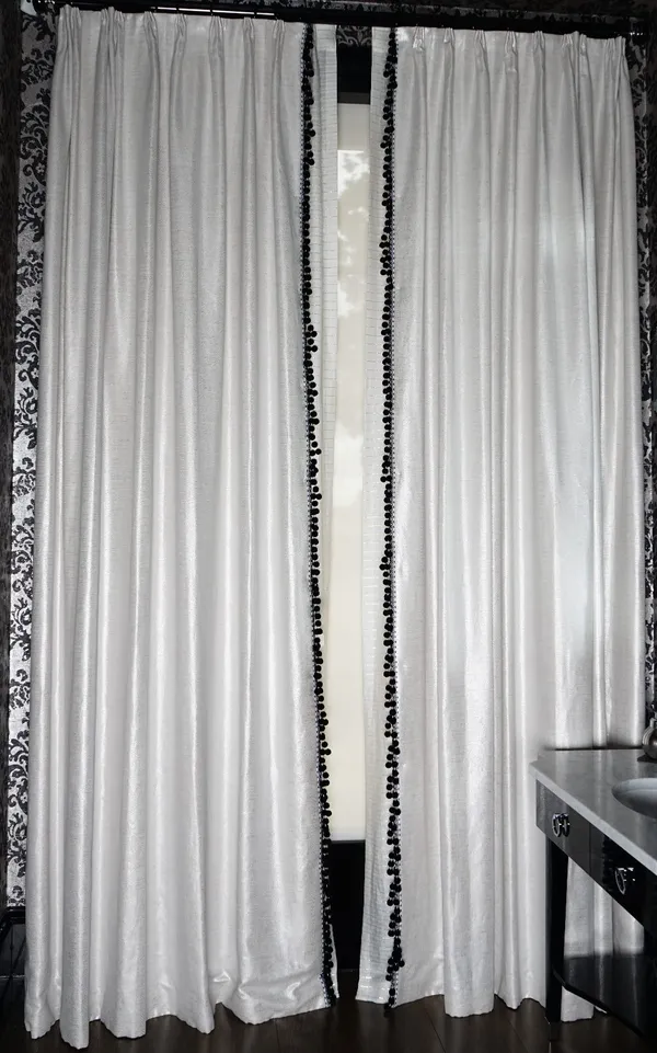 A pair of white silvered woven curtains, with black and white bobbles. 115cm wide x 315cm long.