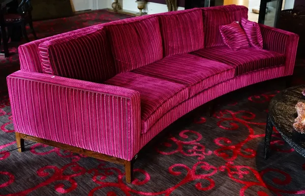 A contemporary curved three seat sofa, upholstered in striped black and magenta with loose back and seat cushions, with faux rosewood frames, with one