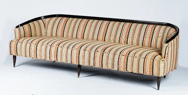 A sleek sofa, circa 1950, with curved dark stained frame, upholstered in orange and brown stripe fabric, 230cm wide 73cm high.