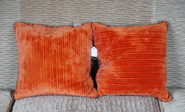 A pair of orange velvet and cable-knit woven fabric cushions (2).