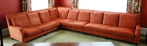 A contemporary sectional sofa, upholstered in orange and brown leopard chenille fabric with loose back and seat cushions, on square tapered legs.440cm