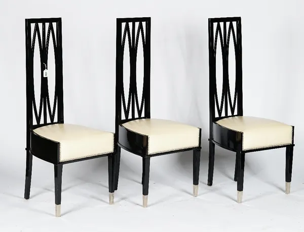 A set of six French black lacquered modernist chairs, 20th century, the high backs with twin navette shaped splats, the stuff-over seats in cream leat