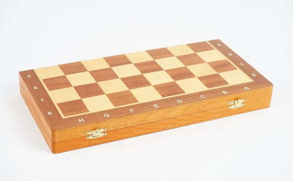 A contemporary turned and carved wooden chess set, one half natural, with a folding mahogany and satinwood games board.