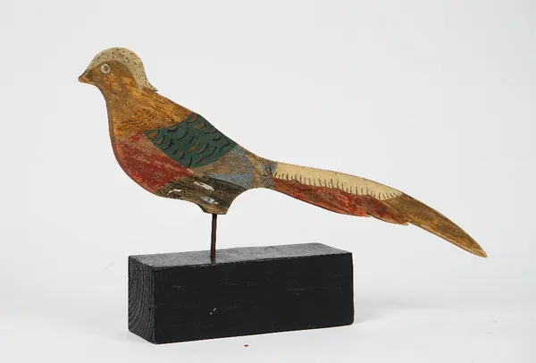A polychrome painted wooden figure of a pheasant on an ebonised block wooden base.