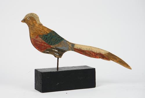 A polychrome painted wooden figure of a pheasant on an ebonised block wooden base.