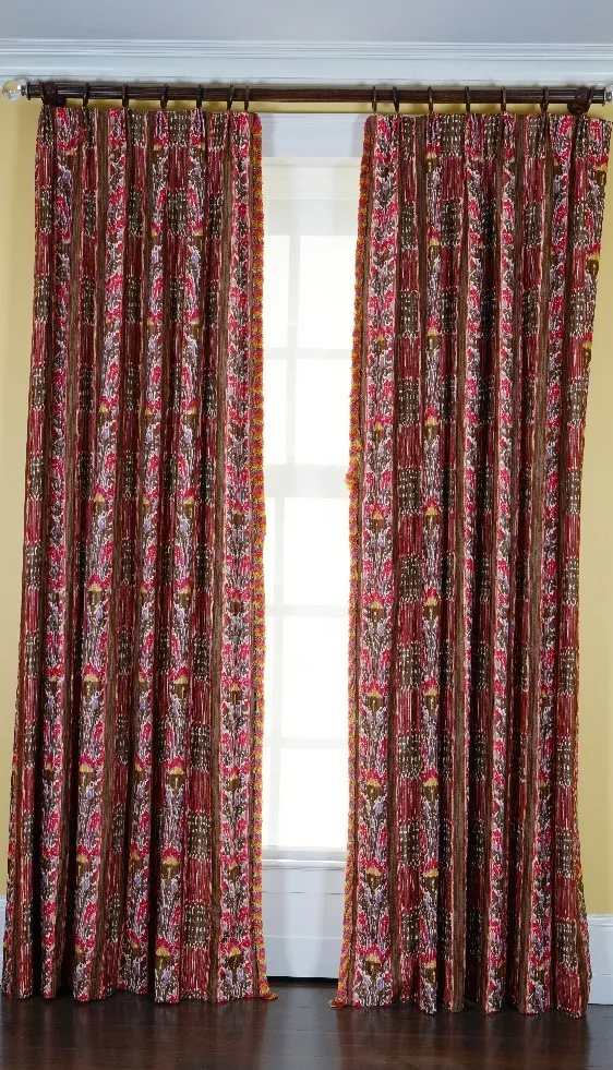 A pair of linen curtains printed with multicoloured designs, with tasseled edging. 80cm wide x 310cm long.