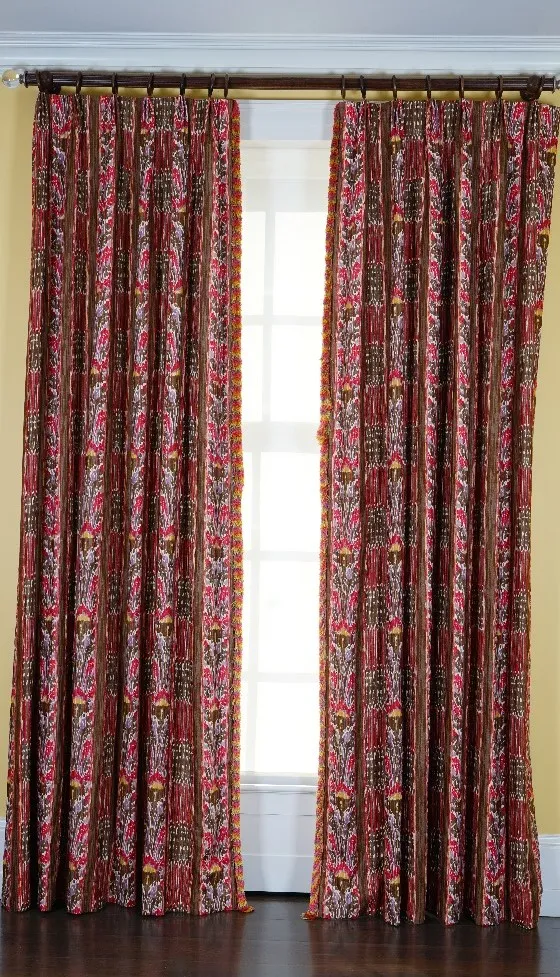 A pair of linen curtains printed with multicoloured designs, with tasseled edging. 180cm wide x 310cm long.