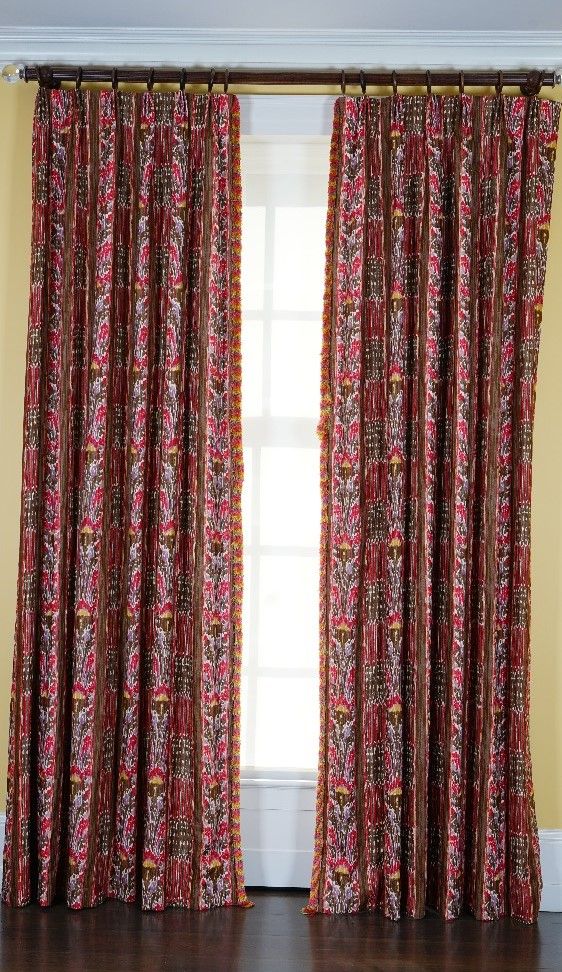 A pair of linen curtains printed with multicoloured designs, with tasseled edging. 90cm wide x 310cm long.